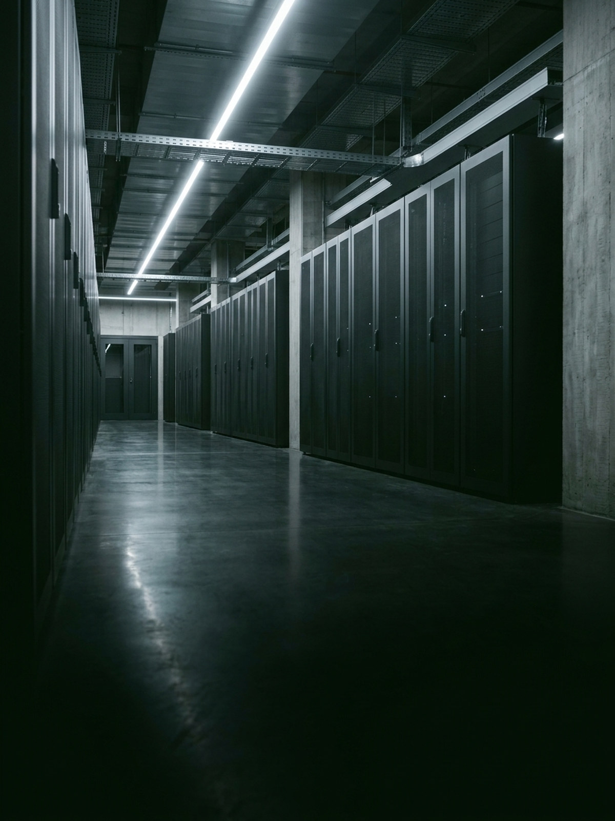 Data center aisle at night under white service lighting