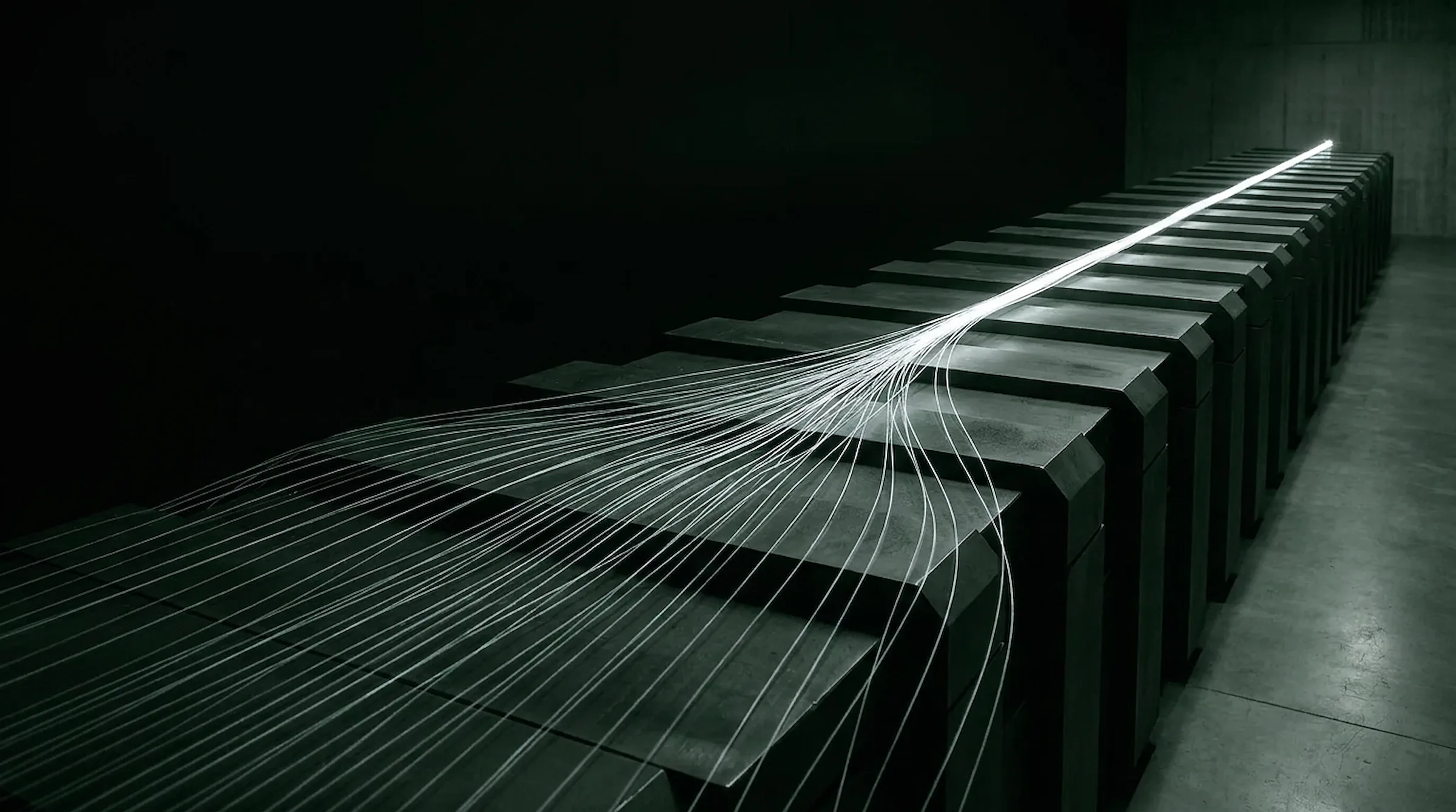 Long-exposure light threads converging into a single bright seam across dark machinery