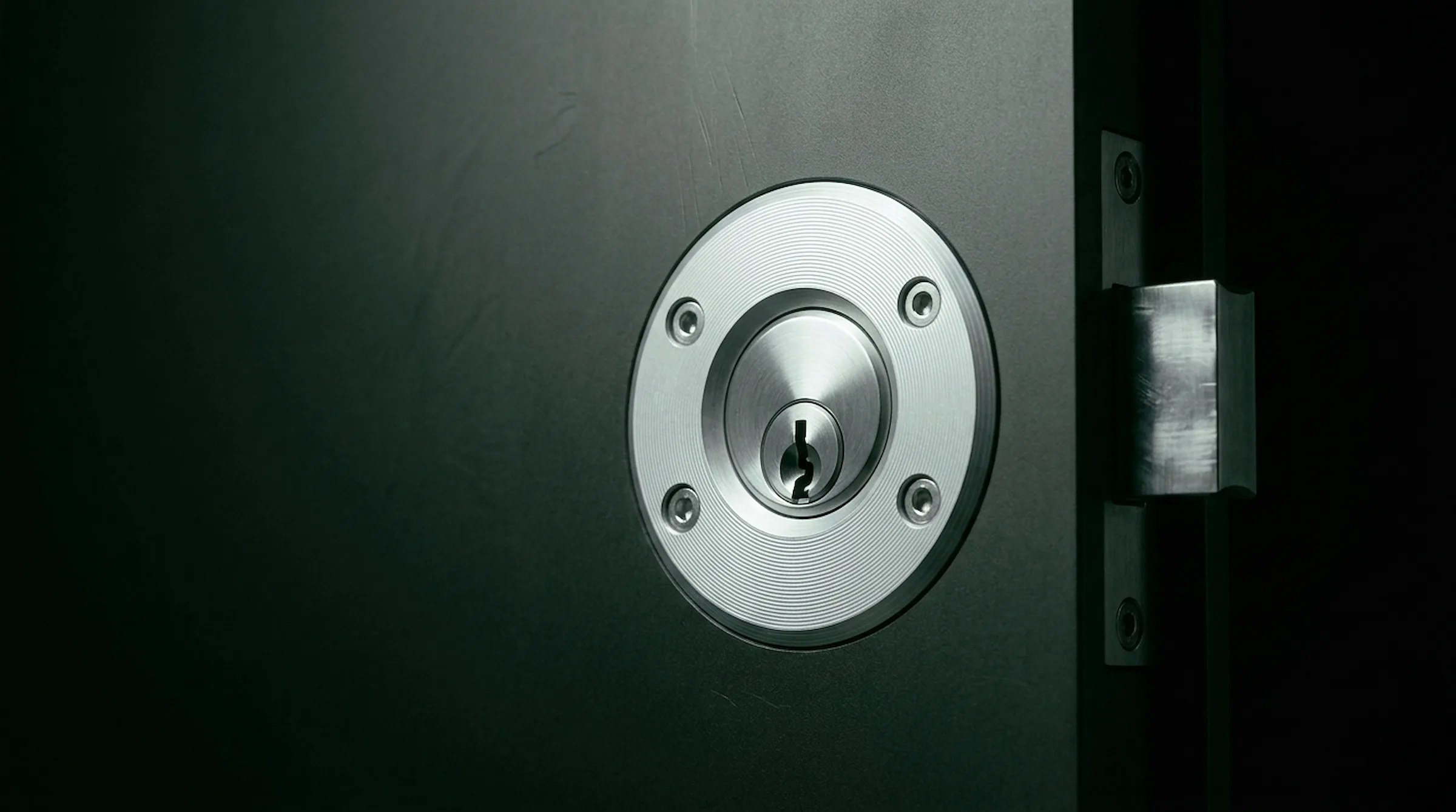 Macro of a machined dark keyed lock mechanism - precision-cut metal under cool white light